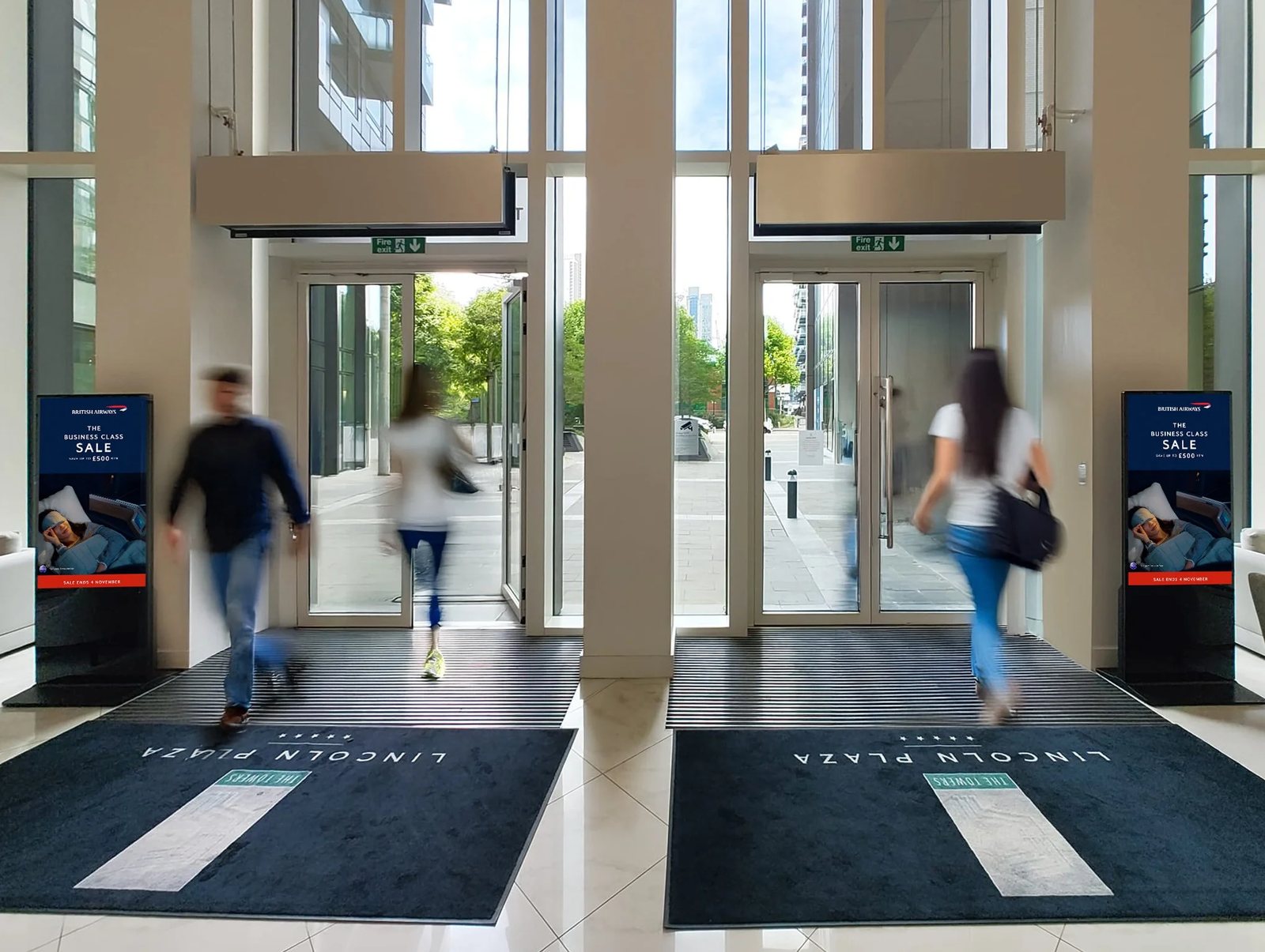 Two Abode digital totems carrying a British Airways campaign either side of a residential building entrance