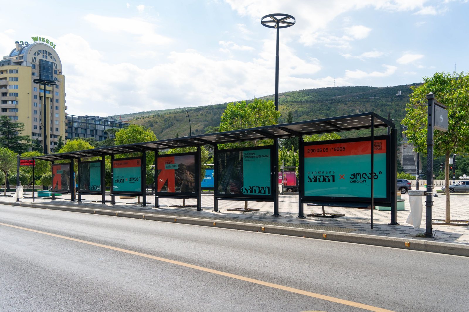 A run of ALMA bus shelters with advertising panels on a Tbilisi boulevard